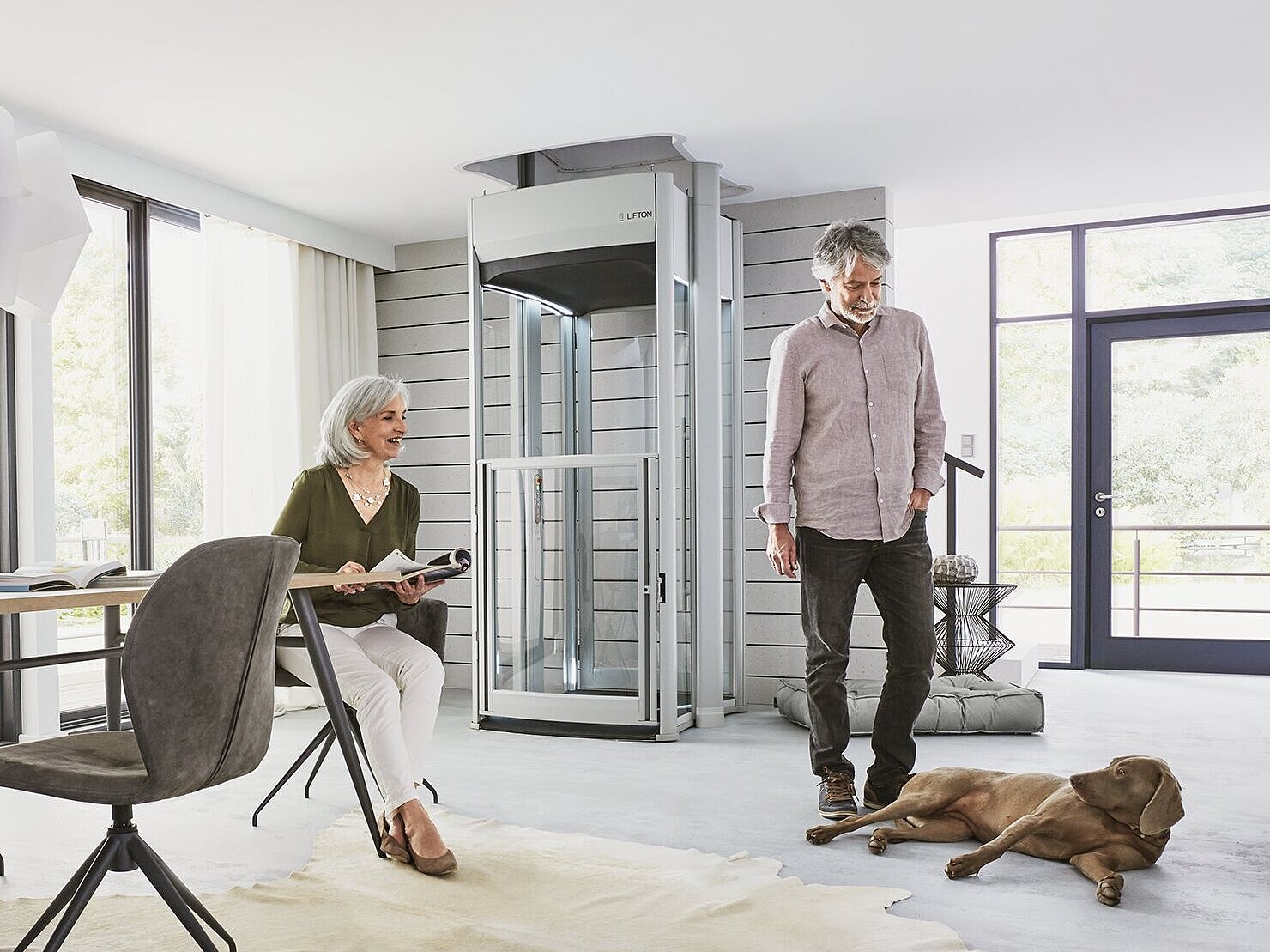 Älteres Ehepaar steht vor ihrem Lift im Wohnzimmer