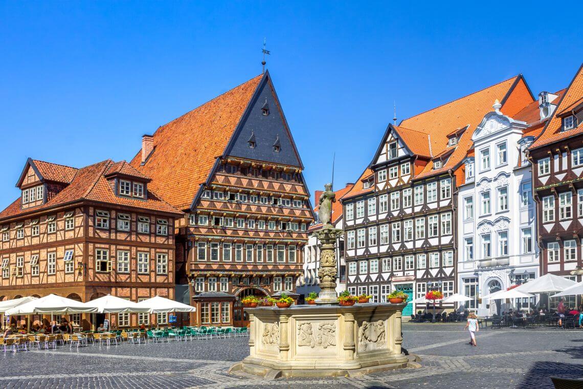 Marktplatz in Hildesheim mit historischen Fachwerkhäusern und Steinbrunnen